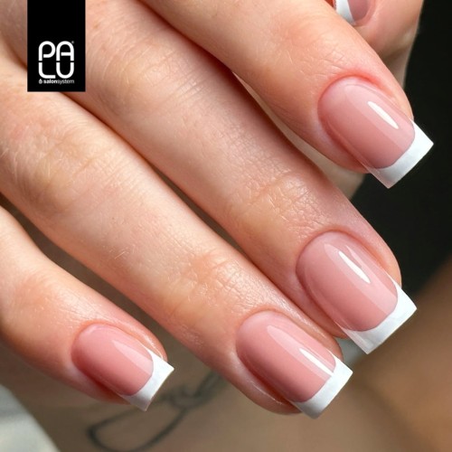 Klasyczny french manicure z różowym żelem Pro Light Builder Classic. Dłoń prezentująca zadbane, błyszczące paznokcie french